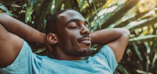 The man relaxing outdoors surrounded by tropical foliage and warm golden sunlight