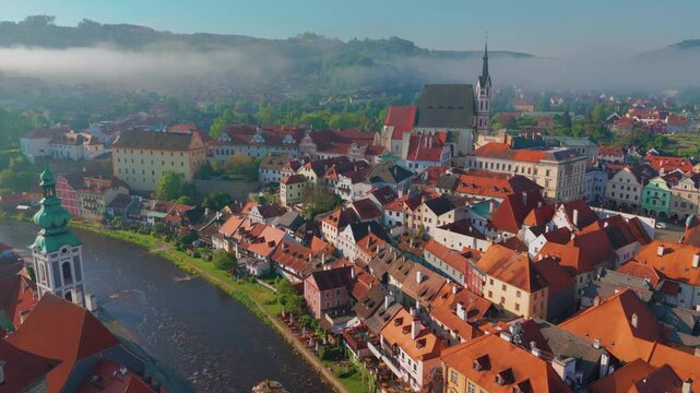 aerial perspective captures the historic UNESCO World Heritage site of Česk&yacute; Krumlov, Czech Republic. The footage showcases the picturesque old town with its distinctive red tiled roofs, the iconic Če