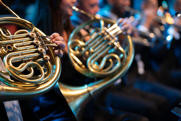 Close-up of a French horn in the hands of a musician during a brass band concert