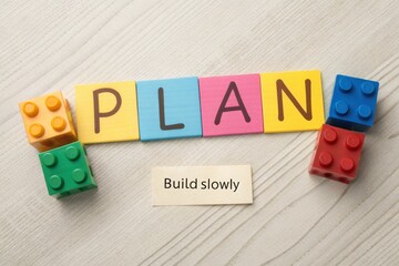 Fototapeta premium Colorful toy blocks spelling plan and creating a motivational concept