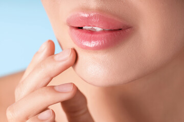 Obraz premium Woman with beautiful lips on light blue background, macro view