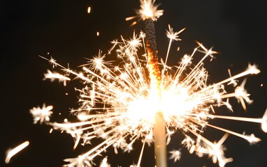 Close up shiny sparkler with festive light sparkles on black background