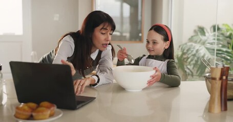 Baking, research and family with laptop, kitchen and teaching muffin recipe to daughter and bonding. Learning, girl and online for dessert preparation, woman and reading tips on web to child in house