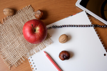 Creative workspace with an apple and nuts on a wooden table