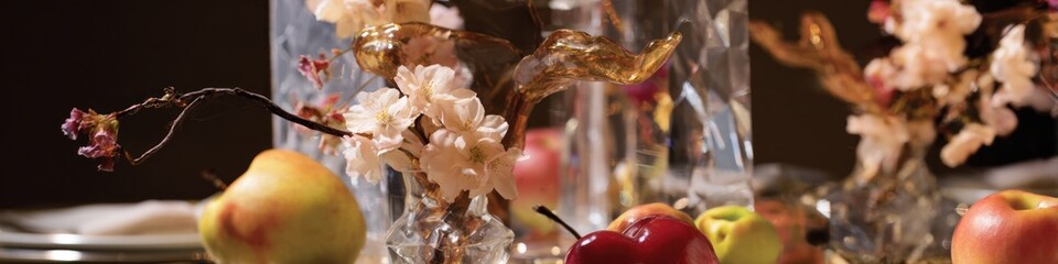 Obraz premium Close up of apples pears and flowers inside a glass vase on a table