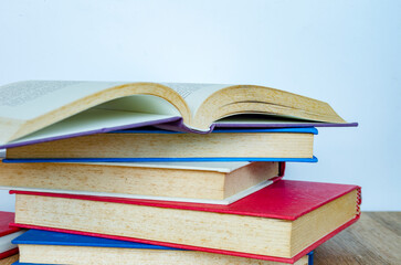 A collection of books with pages curling slightly upward arranged artistically to symbolize creative reading.
