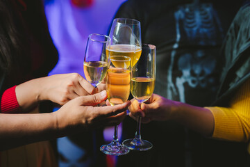 Close-up of people toasting with glasses of champagne or wine, celebrating together at a festive party with joyful atmosphere.