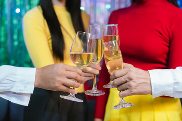 Group of friends clinking glasses of champagne together at a festive party, celebrating happiness and friendship with joyful smiles.