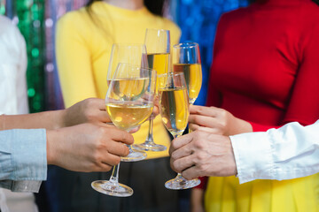 Group of friends clinking glasses of champagne together at a festive party, celebrating happiness and friendship with joyful smiles.