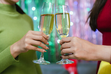 Group of friends clinking glasses of champagne together at a festive party, celebrating happiness and friendship with joyful smiles.