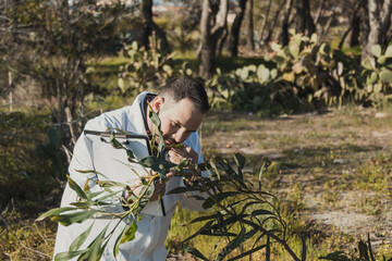 Fototapeta premium Herborist Smelling The Green Plant In The Nature