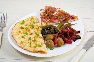 Omelette with toast, olives and sun-dried tomatoes. Tasty omelet breakfast