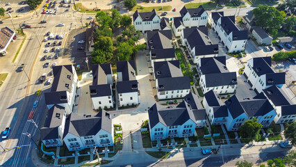 Cooper and Abram, Main Street intersection in Arlington, Texas with gated townhomes, retail storefronts, gas station converge near college campus, dense mixed-use development and transit access