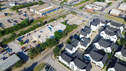 Downtown Arlington, Texas showing gated townhomes, flat roof commercial buildings, railroad tracks. Busy Cooper and Main Street frame a transit-rich corridor near college campus and retail zones