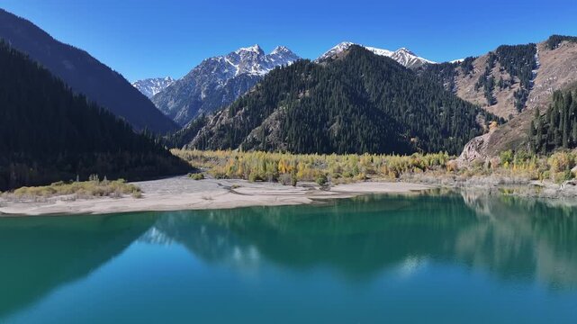 A quadcopter view of Lake Issyk (Almaty Region, Kazakhstan) and the mountain river flowing into it on an autumn morning.