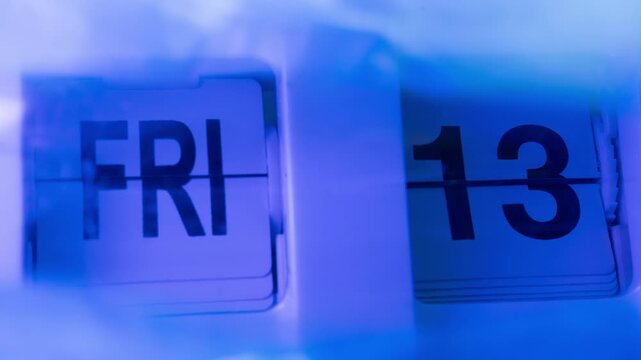 Stop-motion of a flip calendar moving fast and stopping at Friday the 13th