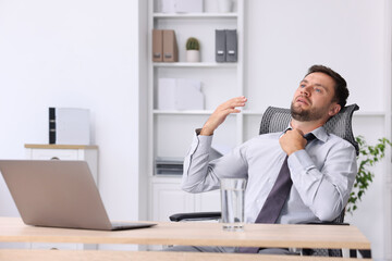 Air conditioning. Man suffering from heat at workplace in office