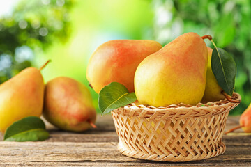 Fresh ripe pears on wooden table outdoors, closeup