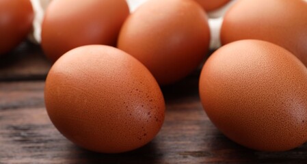 Raw chicken eggs on wooden table, closeup