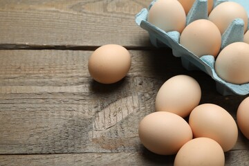 Raw chicken eggs on wooden table, closeup. Space for text