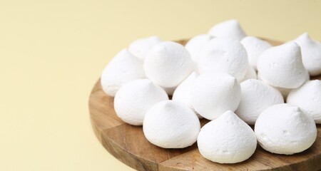 Yummy meringue cookies on beige background, closeup. Space for text