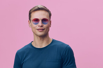young man wearing pink and blue sunglasses casual blue shirt standing isolated pink background smiling portrait digital detox mental health wellness concept