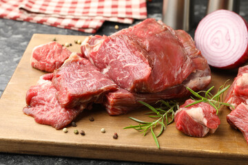 Pieces of raw beef meat and spices on table, closeup