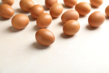 Many raw chicken eggs on light table, closeup