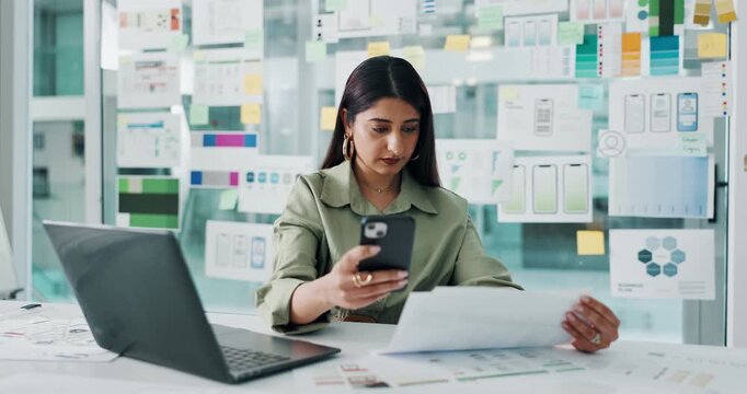Documents, phone and ux with business woman at desk in office for development process or review. App, laptop and paperwork with mobile designer in workplace for communication, planning or usability