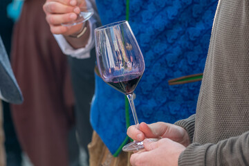 A man holds a glass of red wine during a tasting at a festival in Austria.