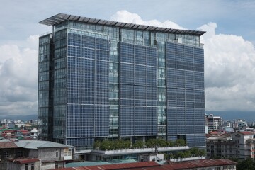 Modern office building with solar panels across the skyline in an urban setting during a cloudy day