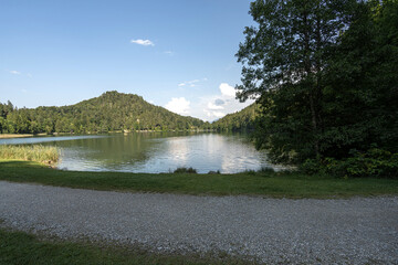 Scenic view of calm lake surrounded by mountains on a clear sunny day