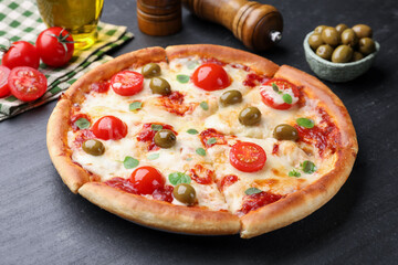 Delicious pizza with cheese, tomatoes and olives on black table, closeup