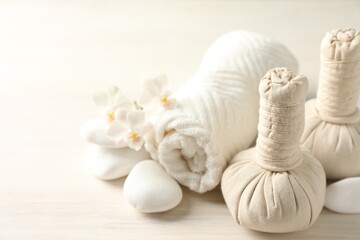 Beautiful spa composition with herbal bags on white wooden table, closeup