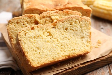 Freshly baked cut cornbread on wooden table, closeup