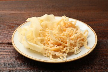 Dried shredded squid and shavings on wooden table, closeup