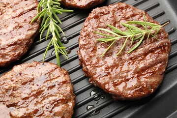 Pan with grilled patties and rosemary, above view