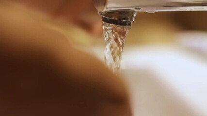 Hygiene demonstration, a person cleaning their hands under running water, promoting proper hand washing habits in a