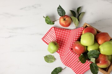 Fresh ripe apples in crate on white table, flat lay. Space for text