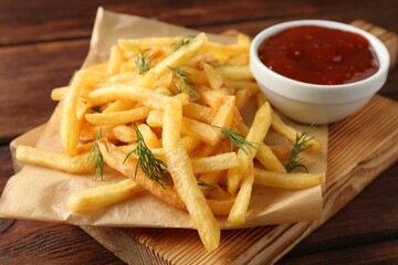 Tasty french fries with sauce on wooden table, closeup