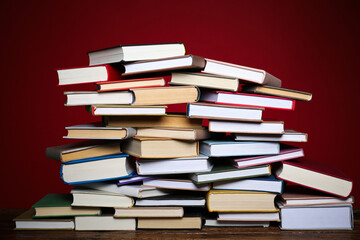 Many books on table against red background