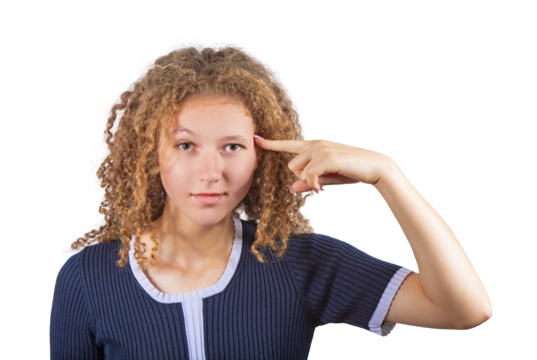 Discontent teenage girl with curly hairstyle points her index finger to her temple looking dissatisfied to camera. Frizzy young woman adolescent isolated on transparent background