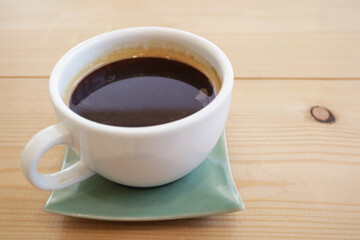 Closeup of an aromatic hot coffee on wooden table