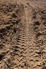 traces of a tractor on a field during tillage, soil in a field with traces of passing heavy agricultural machinery after tillage
