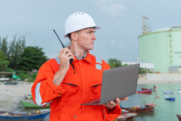 Engineer at LNG Facility Holding Laptop