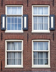 Four architectural windows in a brick building