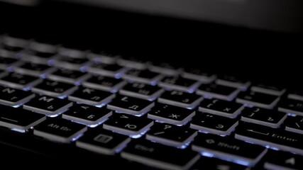 Close Up of an Illuminated Keyboard Featuring RGB Lighting for Aesthetic Appeal. Captivating closeup view of a backlit keyboard, highlighting its vibrant RGB colors and sleek modern design. Movement.