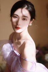 Portrait of a woman in a lavender dress with soft lighting.