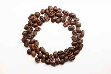 Top view of coffe beans arranged to a decorative circle, isolated on white background