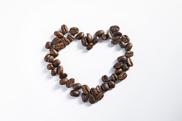 Top view of coffee beans in the shape of a heart, isolated on white background, sharp